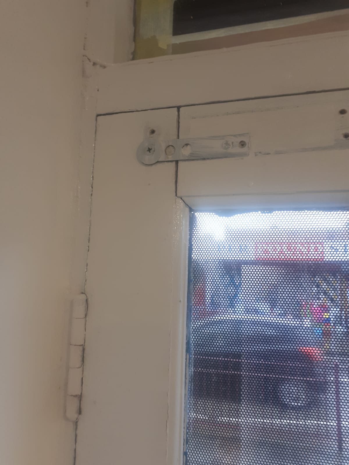 Top pivot and flush bolt at the head of a shopfront door