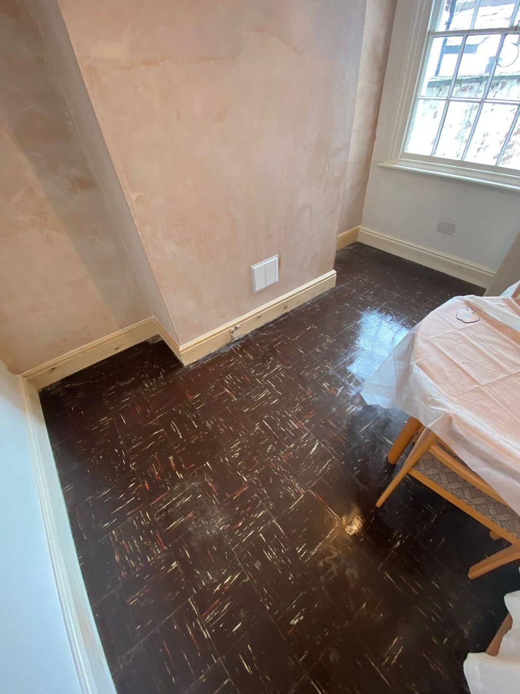 Chimney breast skimmed, with a vent grille Chimney breast and the walls either side in fresh plaster, with a white vent grille above new skirting board