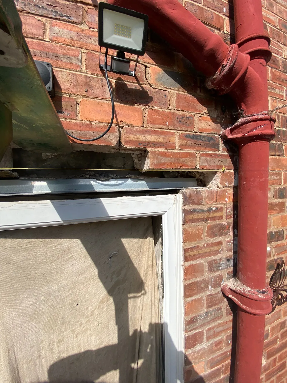 A steel lintel in place over a door opening with the brickwork rebuilt above it