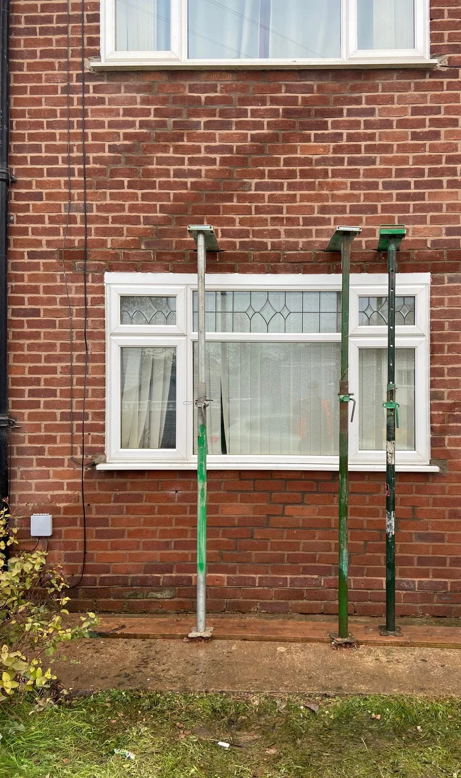 Acrow props supporting brickwork above a window opening during a lintel replacement by Quirks Property Maintenance