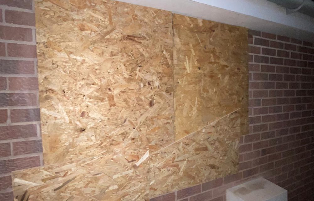 Boarded window on a brick wall photographed at night during an emergency call-out